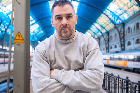 Serious Man in Gray Sweatshirt Standing at Train Station