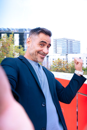 Cheerful Man Taking a Selfie Outdoors in Urban Environmentの写真素材