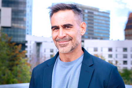 Confident Businessman Smiling in Modern Cityscapeの写真素材