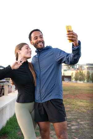 Happy young couple taking a selfie with their smartphone ready to exercise.の写真素材