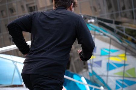 Young athlete running down stairs, doing dynamic exercise outdoors