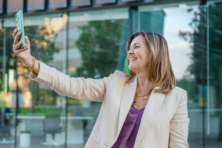 Confident Businesswoman Taking a Selfie Outdoorsの写真素材