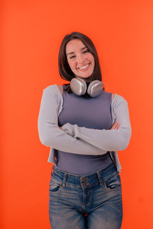 Smiling caucasian woman with red headphones posing against orange backgroundの写真素材