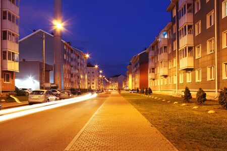 Empty street of town lit by street lights at night.の写真素材