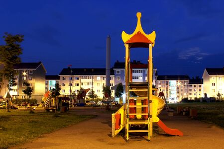Childrens playground at night against the background of a residential areaの写真素材