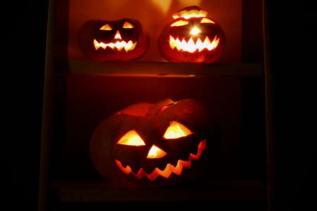 Three halloween pumpkin lantern Jack glowing in the dark. Halloween symbol. Festive decor.の写真素材