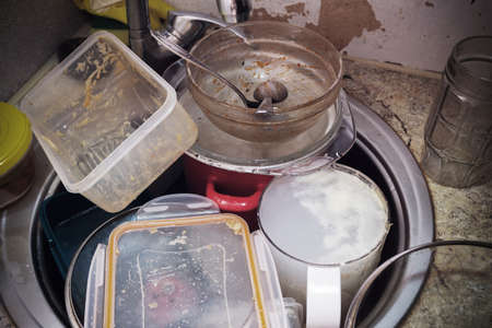 Dirty tableware in the sink in unwashed kitchenの写真素材