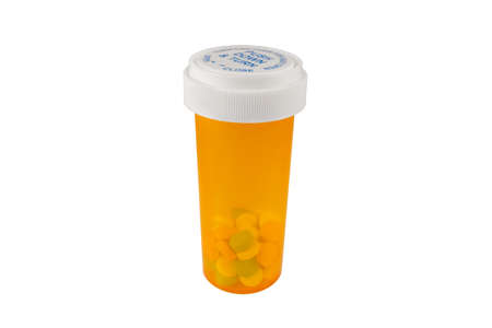 Orange prescription bottle with safety cap with colored pills inside. Isolated on white background.の写真素材