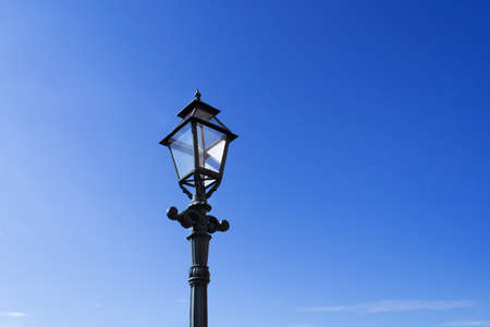 Retro street lamp on clear blue sky background.の写真素材
