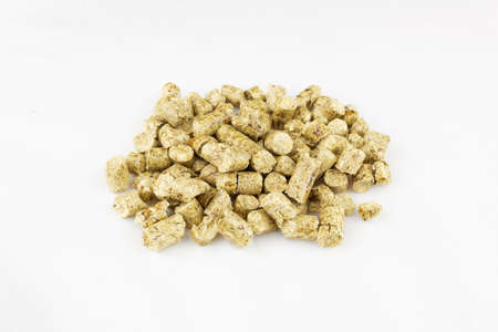 Pile of wood litter for animal toilet on white surface.