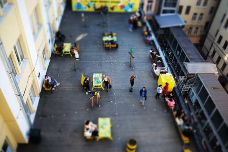 Open-air cafe on the roof with wood flooring, tilt shift effect.