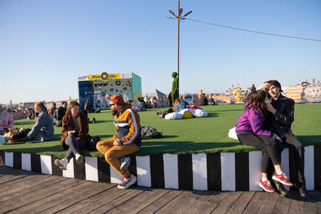 People resting on open air lawn on the rooftop - Loft project Floors Etagi, Saint Petersburg,...