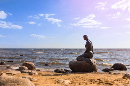 Statue of mermaid on stone on shore of the Gulf of Finland - Komarovo, Saint Petersburg, Russia, June 2021のeditorial素材