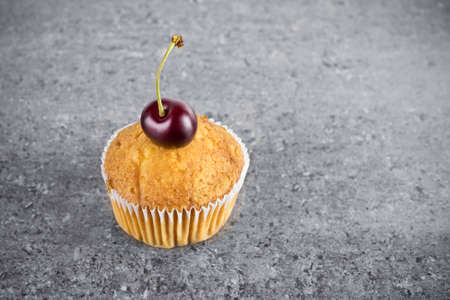 Cupcake with cherries close-up on gray granite tableの写真素材