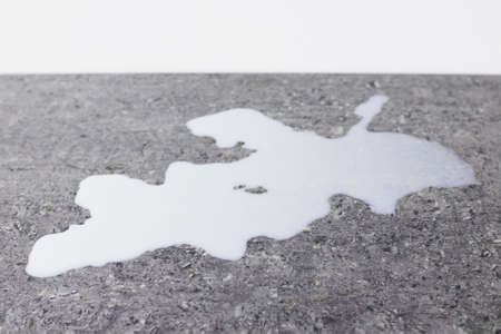 Spilled milk on a gray granite tableの写真素材