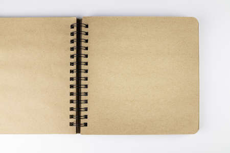 Spring-loaded yellow paper opened notebook on white surface, flat lay