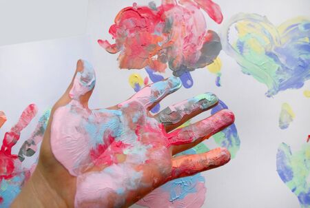 the imprint of a human hand with colorful paint and paint on the handの写真素材