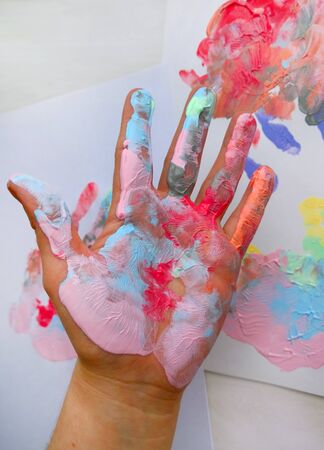 the imprint of a human hand with colorful paint and paint on the handの写真素材