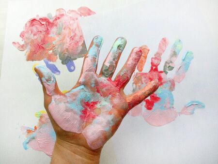 the imprint of a human hand with colorful paint and paint on the handの写真素材