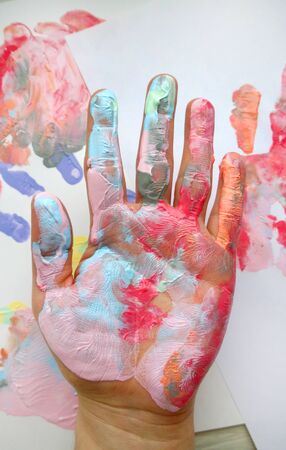 the imprint of a human hand with colorful paint and paint on the handの写真素材