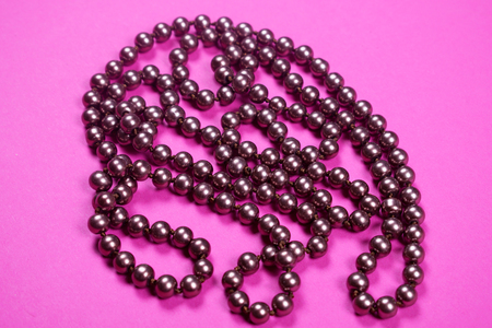 Brown shiny necklace on a pink background,の写真素材