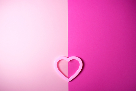 Tender pink heart with a shadow on double-colored background with space for text.の写真素材