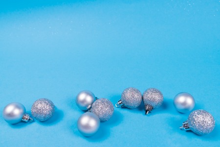 Many beautiful and cute silver shiny and glittering baubles on blue pastel background. New Year and Christmas concept.の写真素材