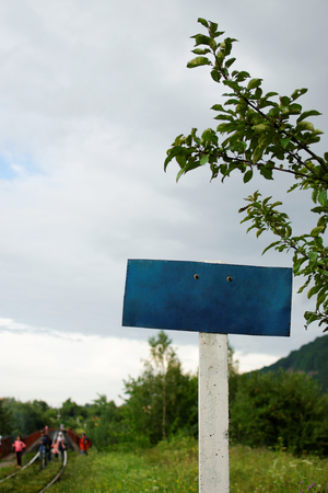 Blue sign plate on a background of kids walking on a railway. Safety concept.の写真素材