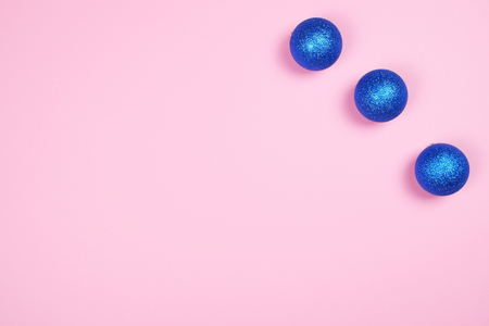 Three beautiful sparkling glitter blue spheres on trendy pastel pink background with copy space.の写真素材
