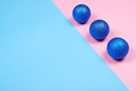 Three beautiful sparkling glitter spheres on trendy pastel pink and blue background with copy space.の写真素材