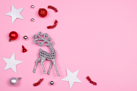 Glitter silver decorative deer and Christmas decoration accessories on pink pastel background with a space for text. Festive concept.の写真素材