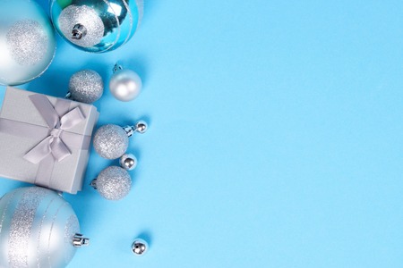 Composition of beautiful silver gift box with cute silky bow and big and small shiny Christmas...