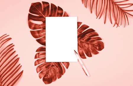 Beautiful shiny artificial leaves of jungle plants and note pad with pen for writing. Elegant...