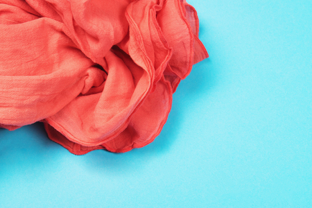 Texture of cotton fabric of vibrant coral color which in the main trend of the year 2019 on blue background. Trendy beautiful backdrop with copy space for text.の写真素材