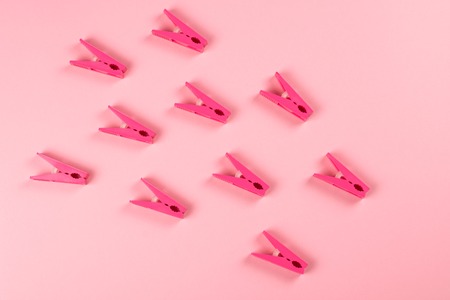 Bunch of clothespins on pink background.の写真素材