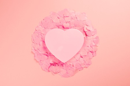 Elegant and tender heart on scattered heart-shaped confetti. The mood of tenderness and love....