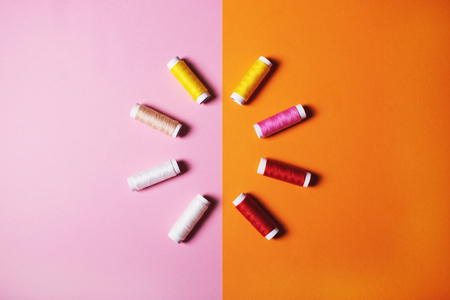 Set of colorful sewing threads on bright background.