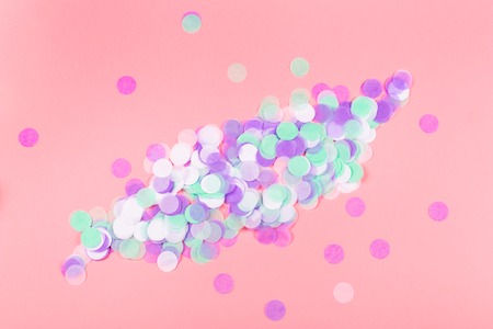 Pink background with colorful round paper confetti with copyspace. Can be used for postcards as a holiday concept.の写真素材