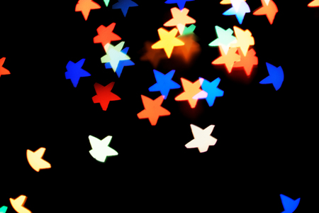Abstract bokeh background with beautiful colorful shiny festive star-shaped lights creating a magic atmosphere. Carnival and holiday celebration concept. Copy space for text.の写真素材