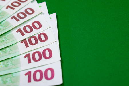 Fan of one hundred euro banknotes on a green background with copy space for text. Budgeting, finance and saving concept.の写真素材