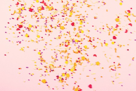 Scattered colorful easter sweet confectionery topping on pink background. Baking and cooking...
