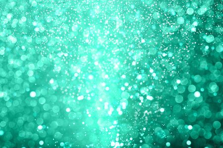 Shiny mint toned defocused glitter background with copy space creating magic atmosphere. Creative holiday and festive backdrop. Color trend of 2020.の写真素材