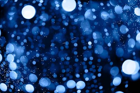 Abstract bokeh background with beautiful shiny festive blue lights creating a magic atmosphere in main color of the year 2020.の写真素材