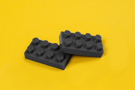 Two gray constructor elements on yellow.