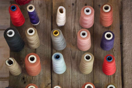 Colorful thread spools on wooden background. Top view. Flat lay.の写真素材