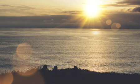 Clouds sky and sunlight sunset on horizon ocean. Silhouette person on background seascape dramatic atmosphere rays sunrise. Relax view waves water sea, mockup nature evening concept perspective sunriseの写真素材