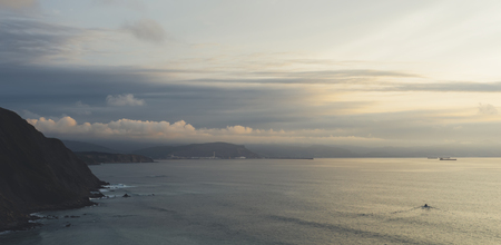 Clouds sky and sunlight sunset on horizon ocean. Mountain on background seascape dramatic atmosphere...