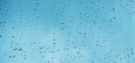Blue glass with raindrops background texture horizontal top view isolated, rain on the window backdrop, light blue sky, clear water on space blank back, mockup nuture wallの写真素材