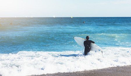 Surfer girl holding surfboard on background sea scape, sand beach coastline. Panorama horizon perspective view ocean, sunlight. Travel summer sport concept, backdrop sunny waves seascape, mock upの写真素材