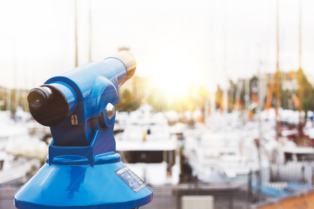 Touristic telescope look at the city with view of Barcelona Spain, close up old blue binoculars on background viewpoint  the pier port yacht, coin operated  in panorama observation nature, mockupの写真素材